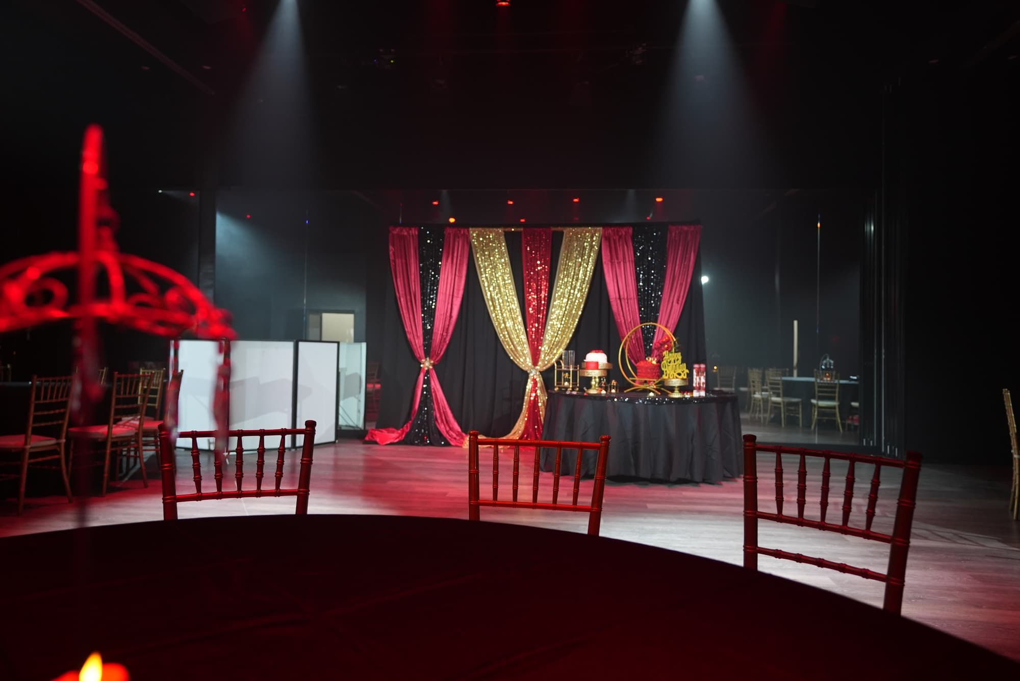 Red and gold drapes and a DJ booth at the end of the hall, lit with spotlights