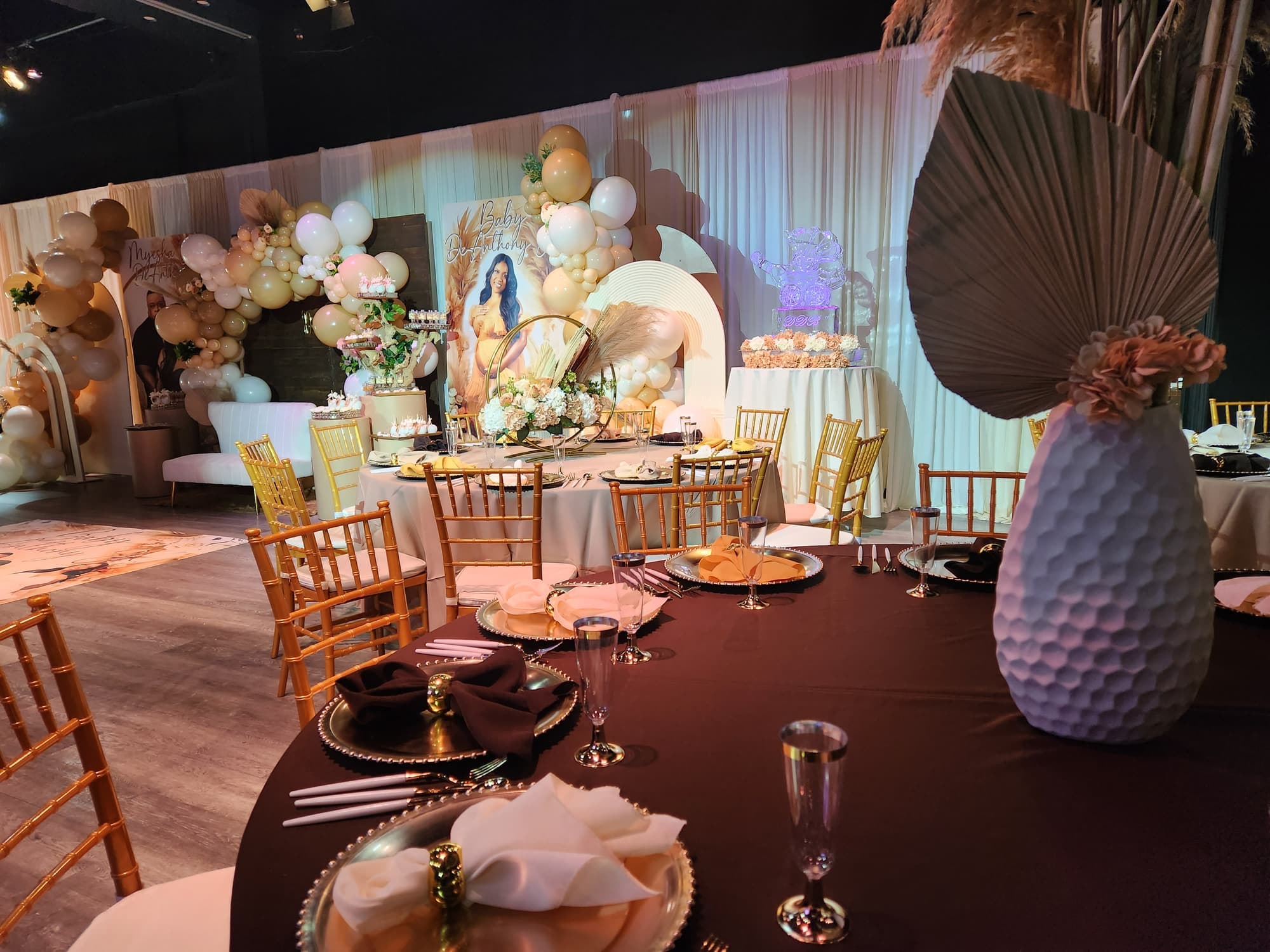 A boho shower backdrop with balloons and dried flowers