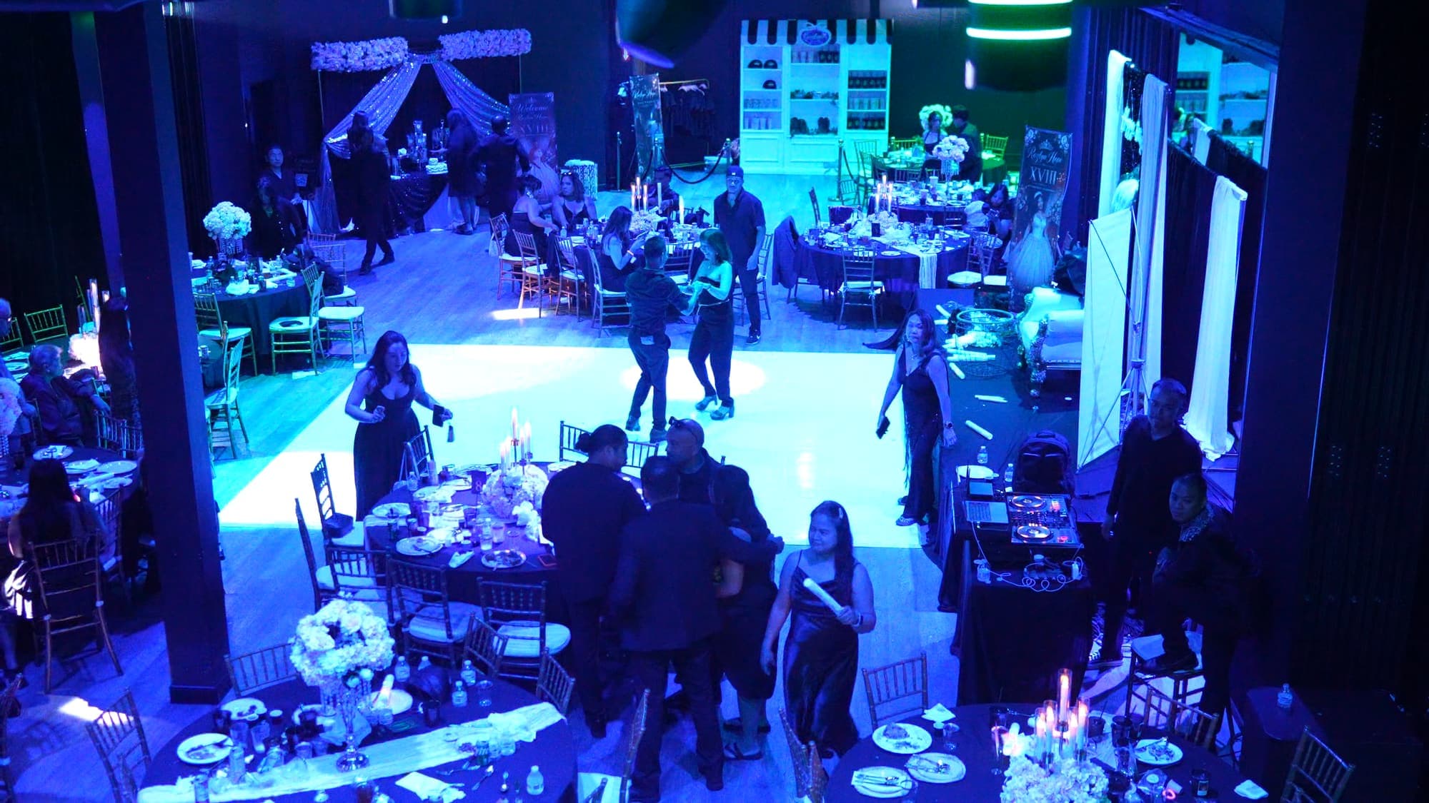An 18th birthday seen from the balcony, with couples on the lit dance floor and round tables all around it