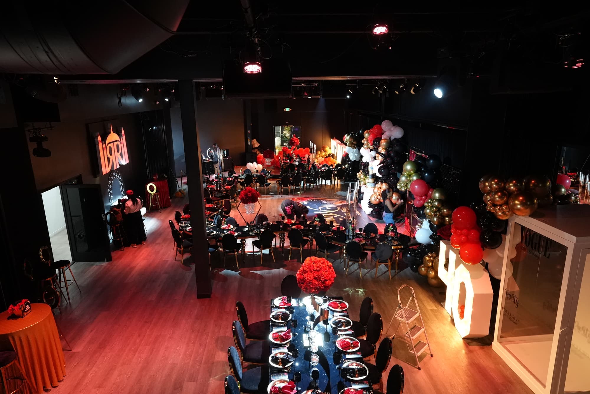 A 40th birthday seen from the balcony, with long tables and the lit 40