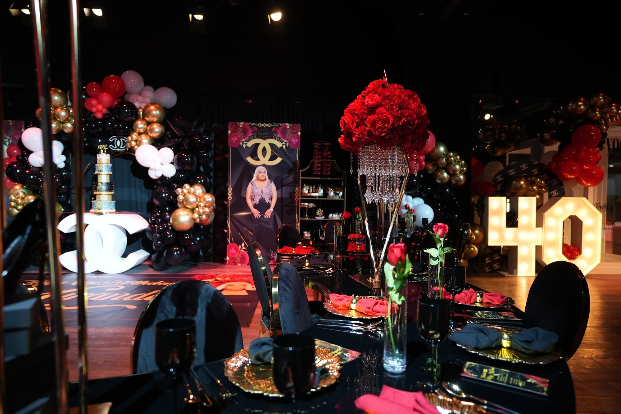 A 40th birthday tablescape with red roses, crystal and a lit 40