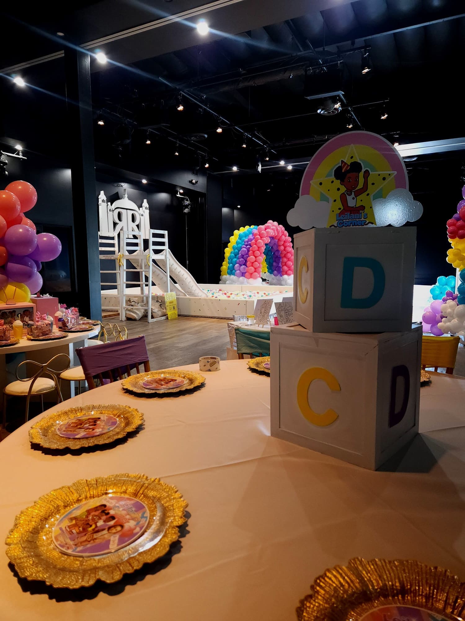 A baby shower table with gold chargers and alphabet blocks