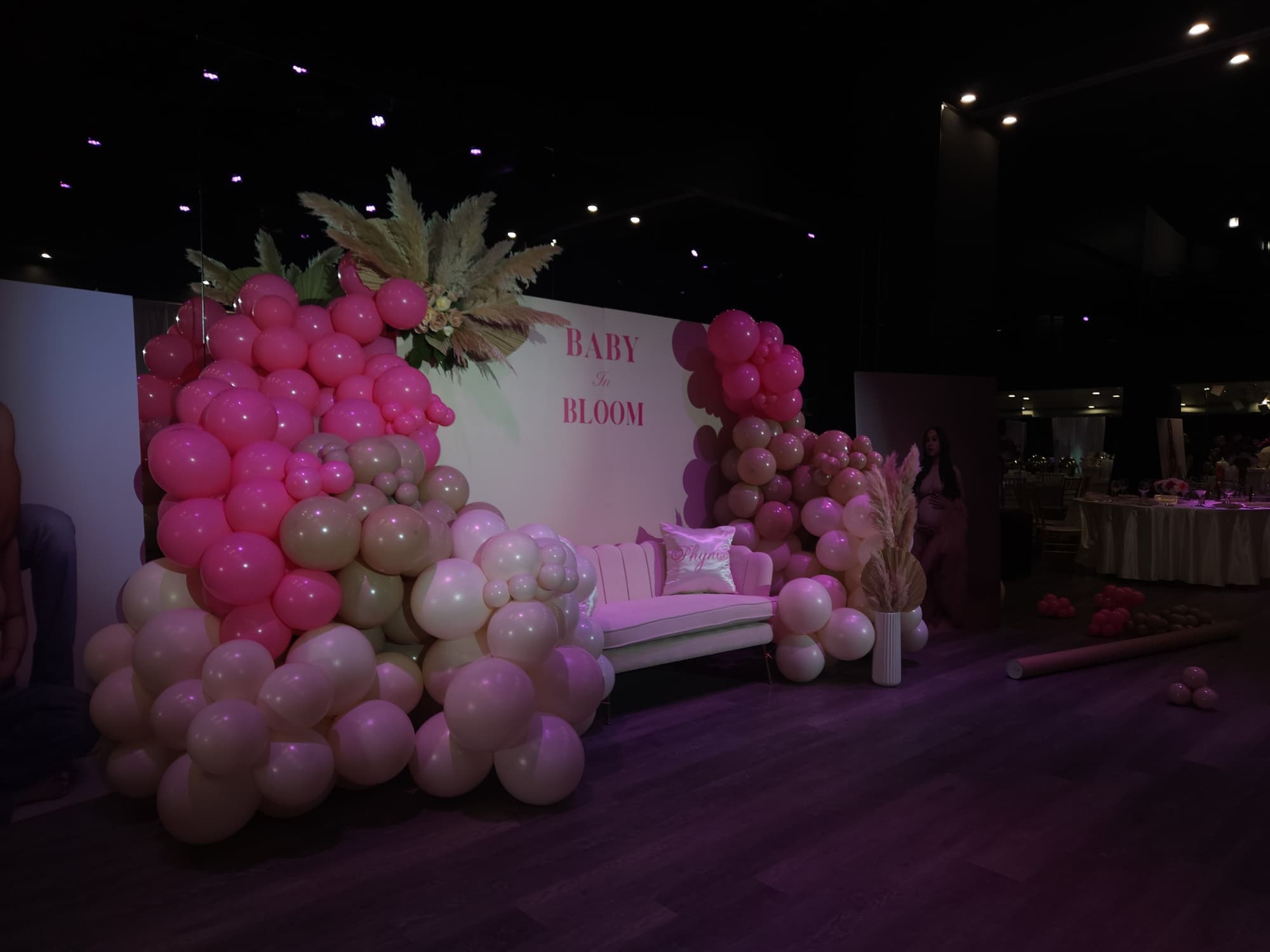 A Baby in Bloom backdrop with pink and cream balloons