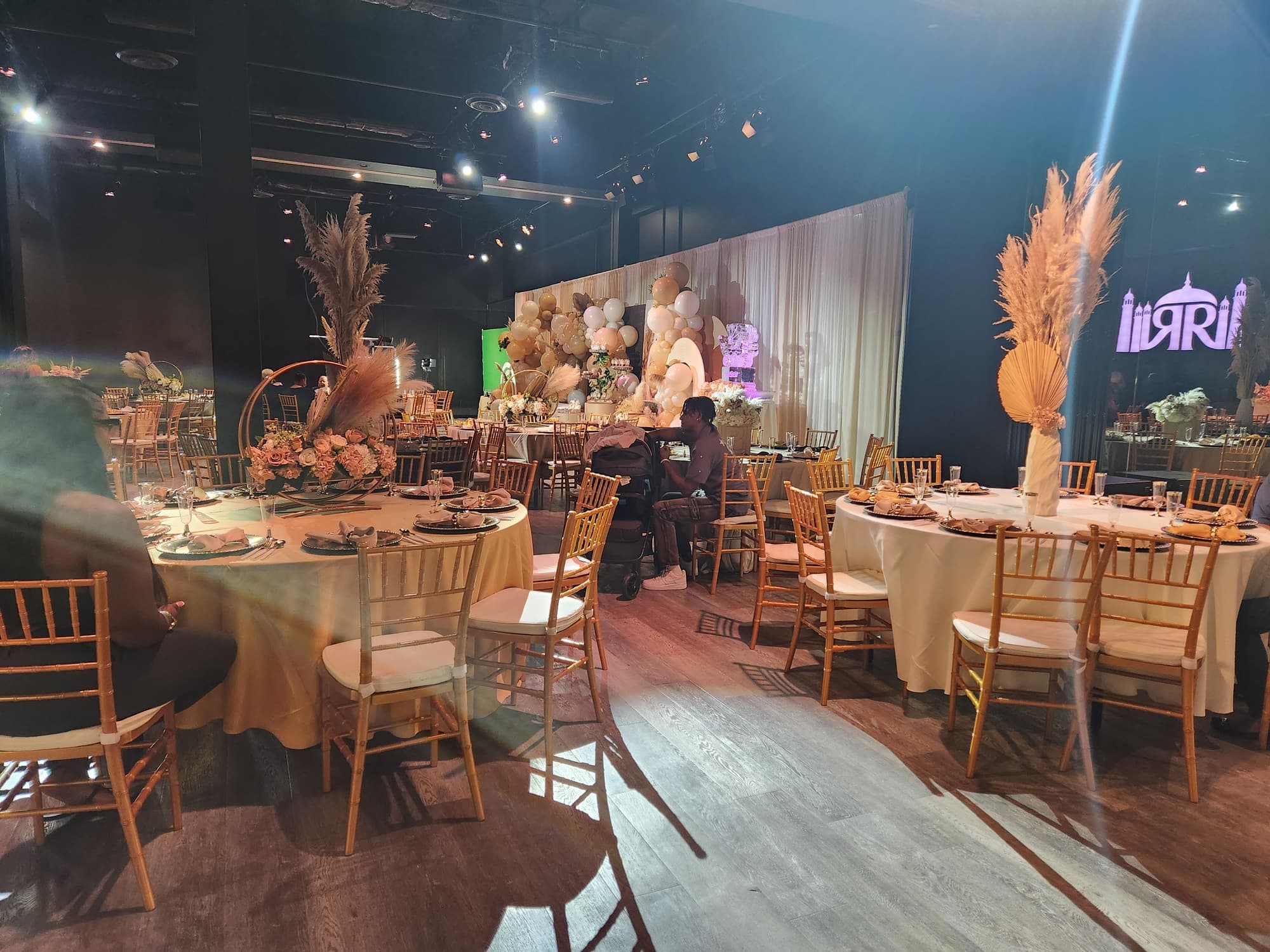 A boho shower with pampas grass, cream linens and gold chairs