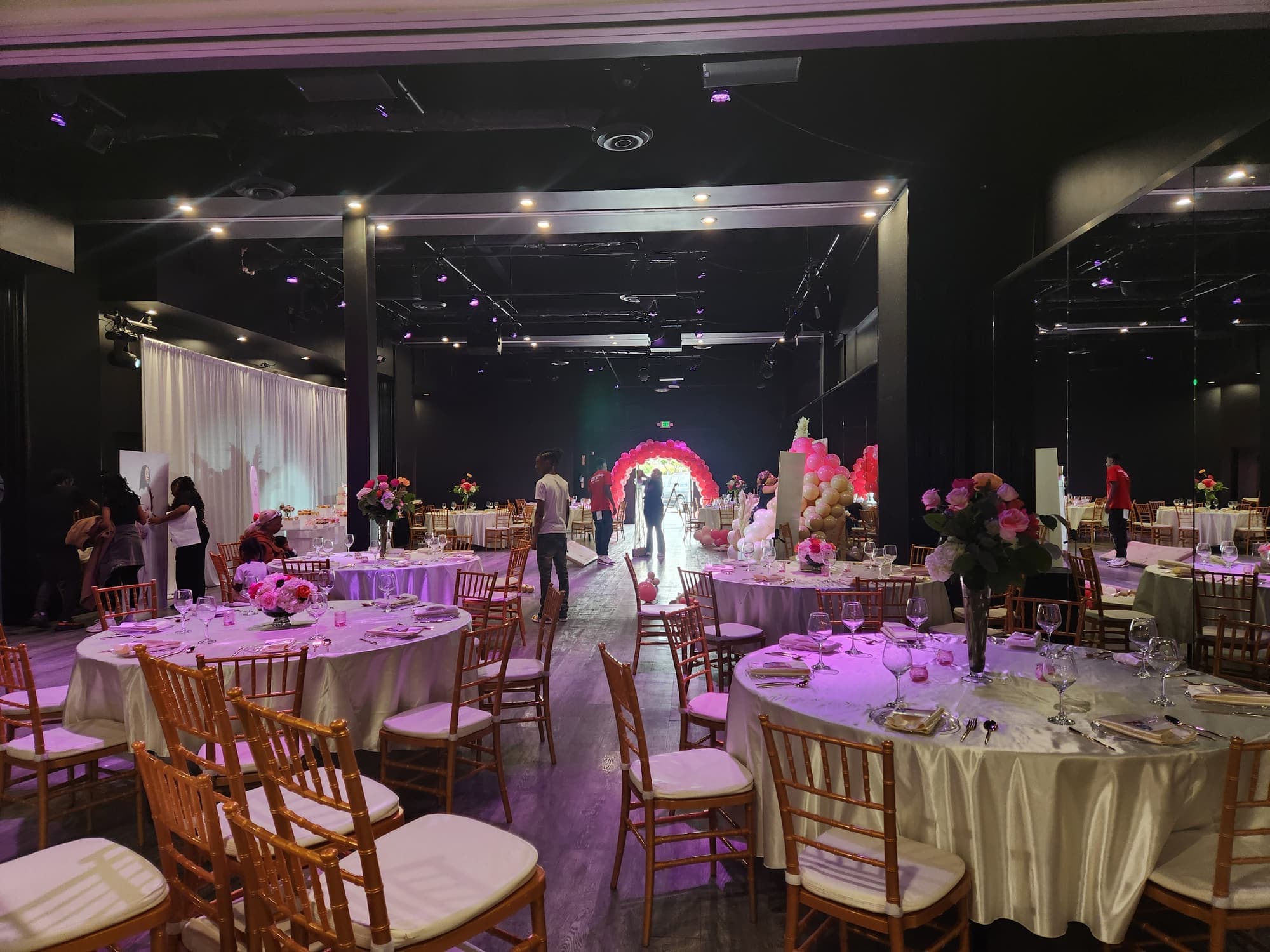 The hall set for a shower with round tables and a balloon arch