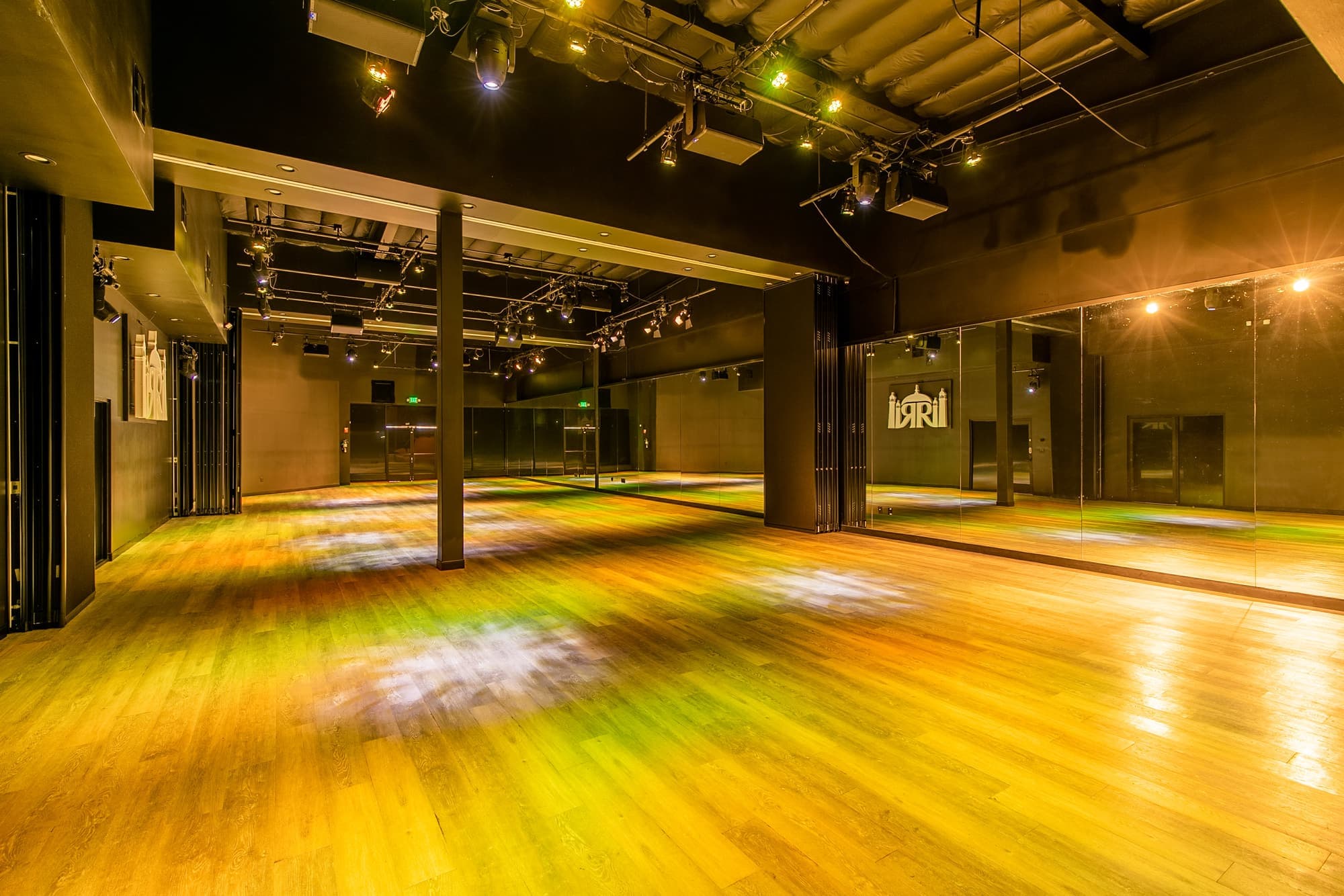 The main hall with warm amber light across the wood dance floor