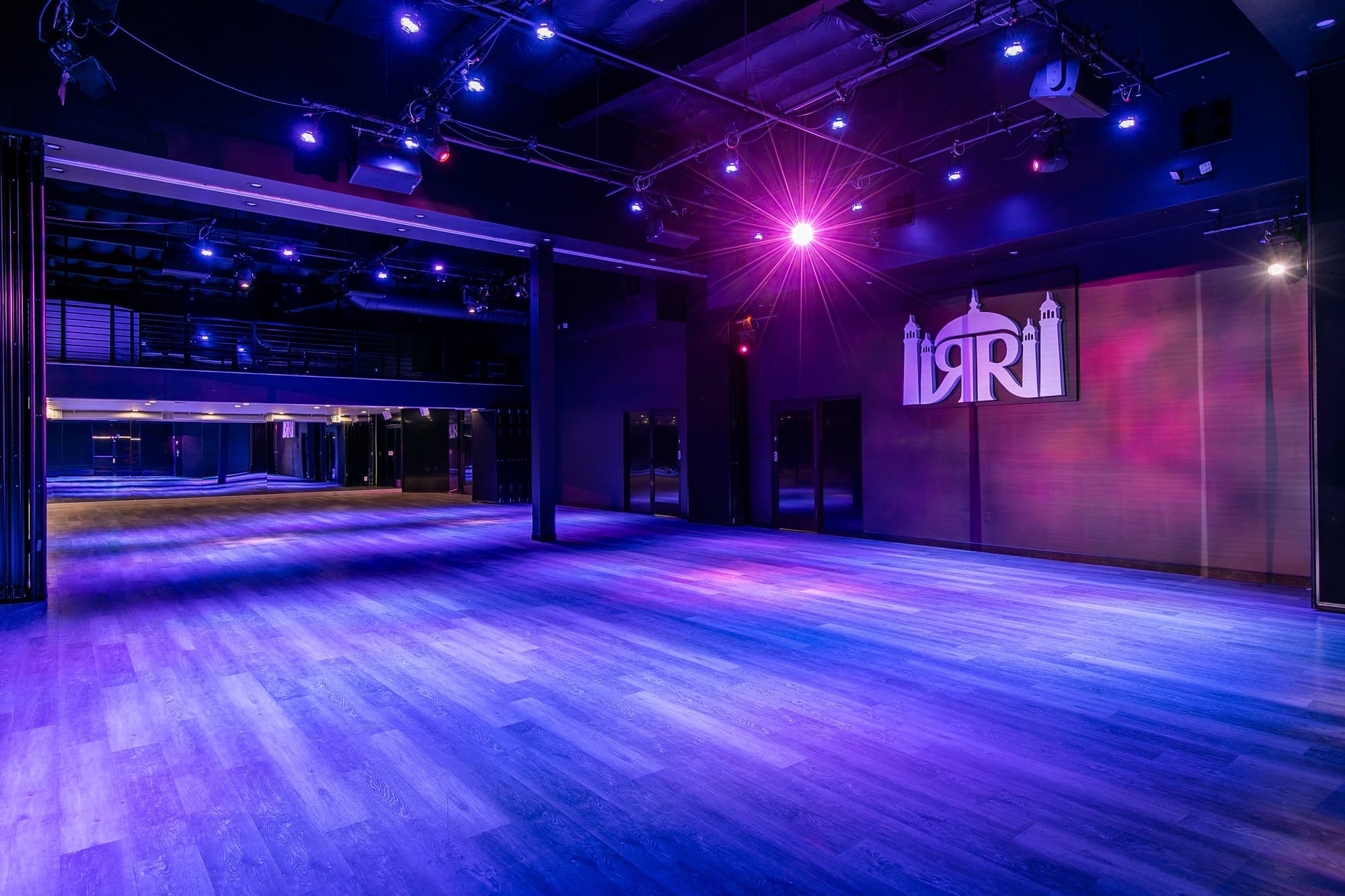 The main hall in blue light with the RRB Studios crest on the far wall