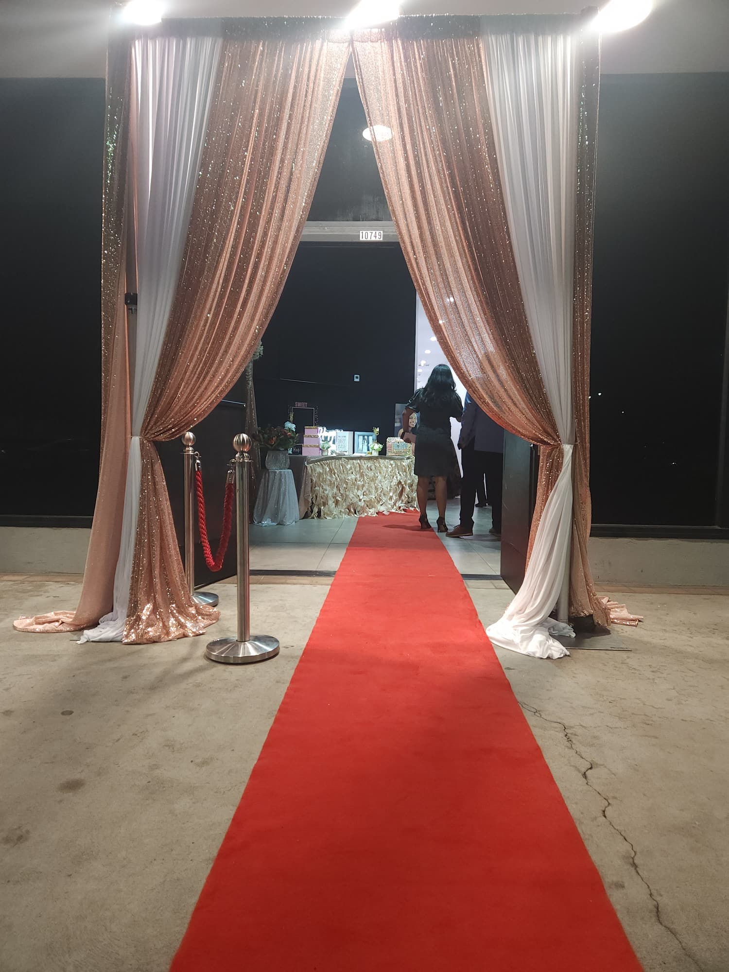 A red carpet entrance through rose gold drapes
